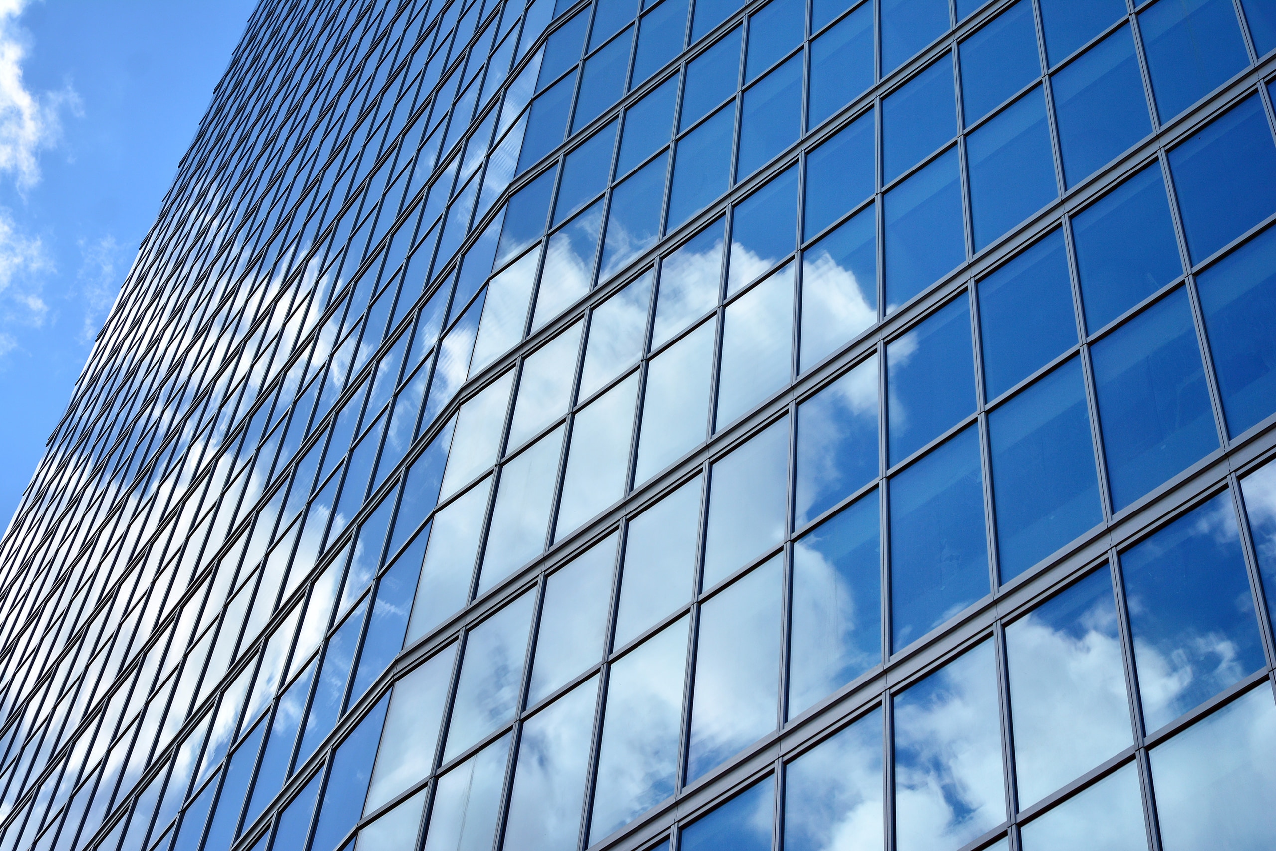Modern glass facade against a clear sky at Cyber Works